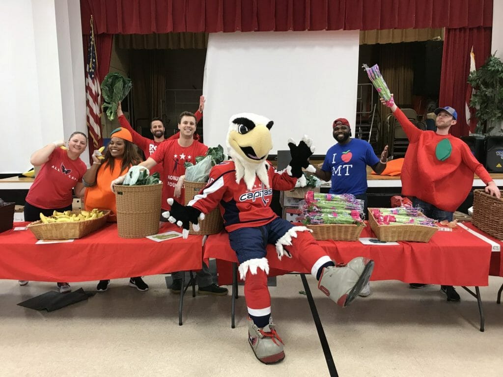 Slapshot poses with MSE employees at Martha's Table event.